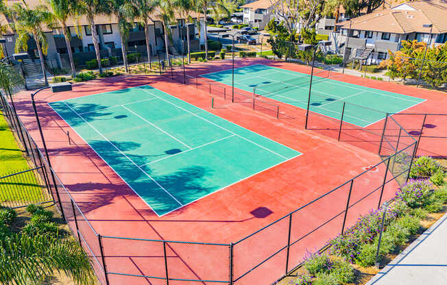A tennis court surrounded by a fence and trees.