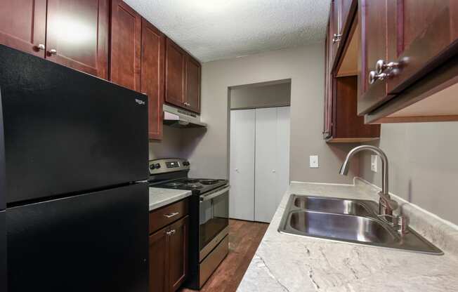 a kitchen with a sink and a stove and a refrigerator. Roseville, MN Rosedale Estates