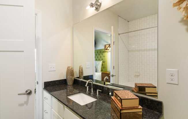 Ashland Farms Bathroom Vanity with Spacious Granite Counters, Large Mirror, and Modern Light Fixtures