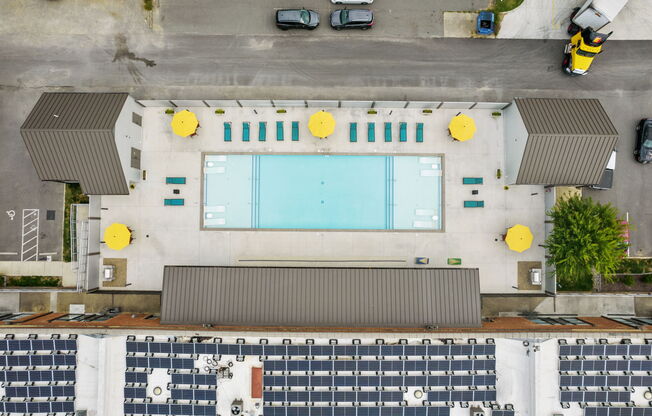 an overhead view of a building with a pool and cars parked around it