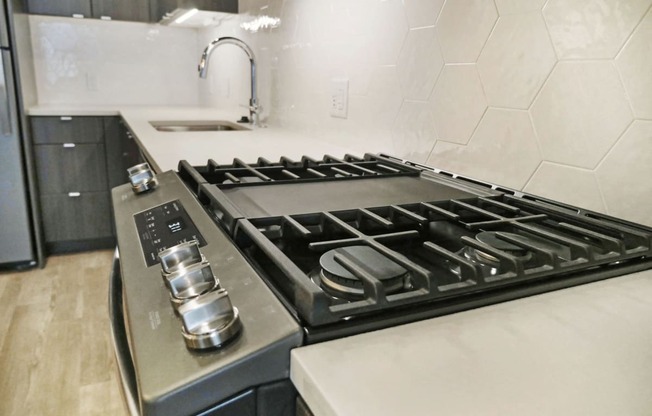 a kitchen with a stove top oven and a sink