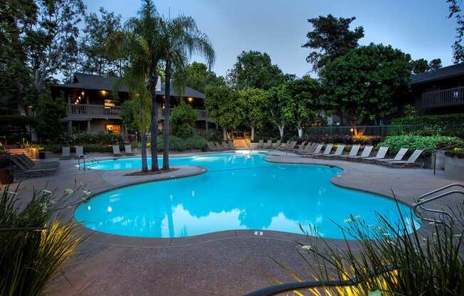 a swimming pool at night at an apartment community