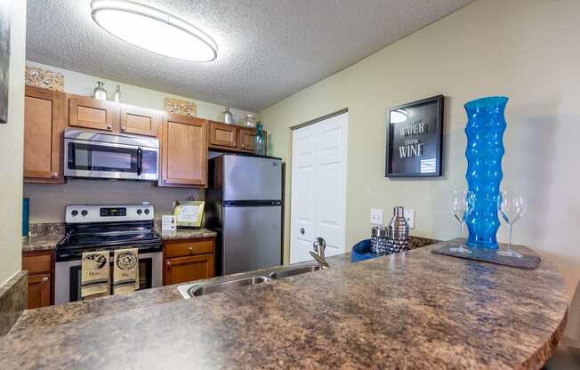 Apartment kitchen countertop with stove, microwave, and refrigerator in Blue Ash, OH.