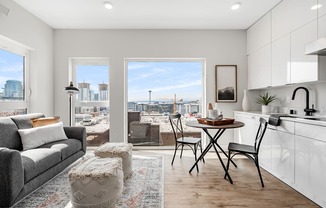 a living room and kitchen with a view of the city  at Oslo, Seattle, 98102
