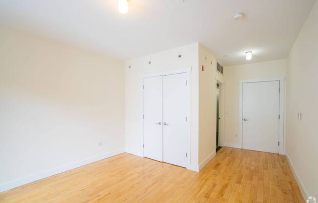 A room with white walls and wooden flooring with two white doors. at 603 Concord Apartments, Cambridge 02138