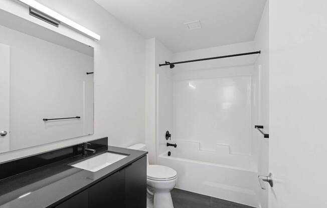 A white toilet sits next to a sink in a bathroom.