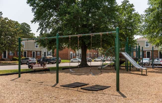 a playground with a swing set and a tree