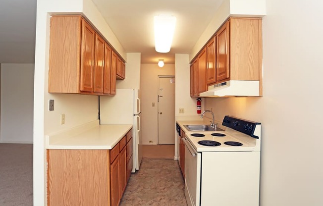 a kitchen with white appliances and wooden cabinets