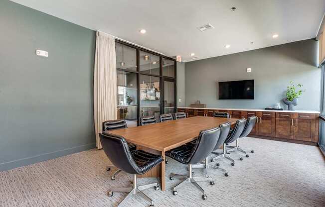 A conference room with a long table and chairs.