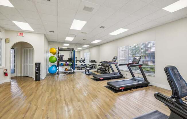 A gym with treadmills, exercise balls, and other equipment.