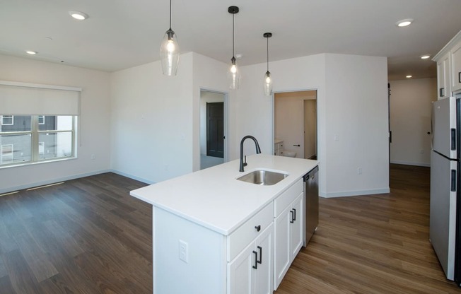 an empty kitchen with a white counter top in a new home at The Crossings at Windsong, Prescott Valley, Arizona
