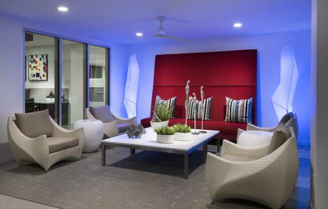 a lounge room with white chairs and a red couch