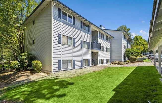 A large two-story apartment building with a well-maintained lawn in front.