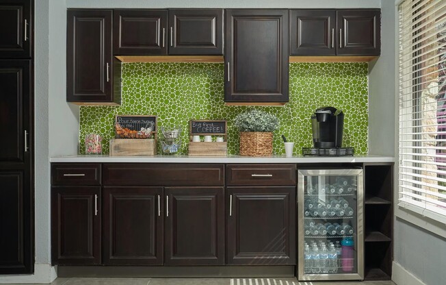 Experience modern living at Distinction Apartment Homes. This sleek kitchen features stylish cabinetry, vibrant backsplash, and convenient beverage fridge—perfect for everyday needs. Elevate your lifestyle today! Schedule a tour now!