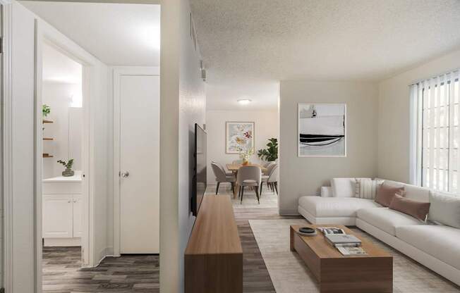 A living room with a white couch and a wooden coffee table.