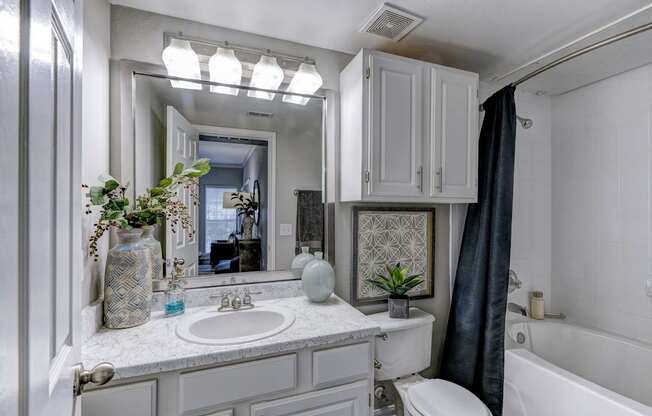 A bathroom with a white tub, sink, and toilet.