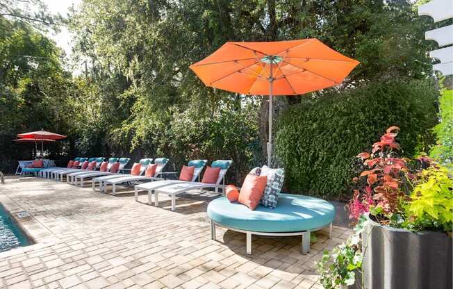 A patio with a pool and a table with chairs.