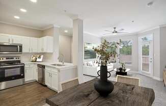 an open kitchen and living room with a large window and a table  at The Verandah, Austin, TX