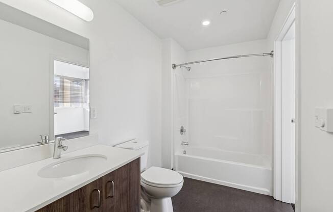 A white bathroom with a toilet, sink, and shower.