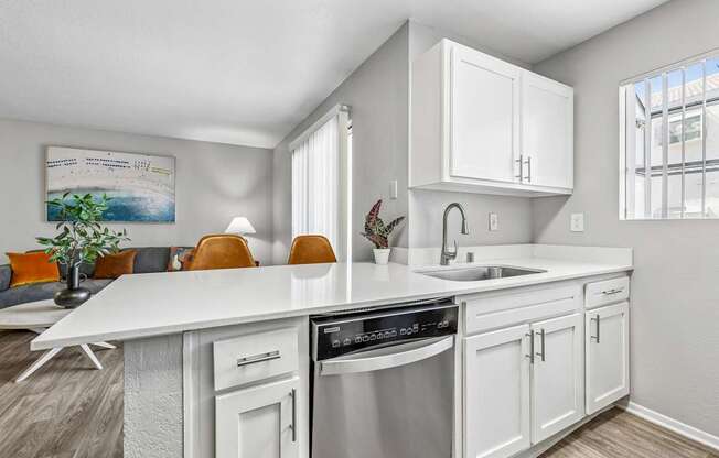 A modern kitchen with white cabinets and a stainless steel dishwasher.