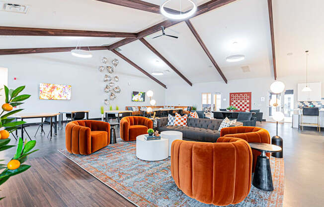 A living room with orange chairs and a grey couch.