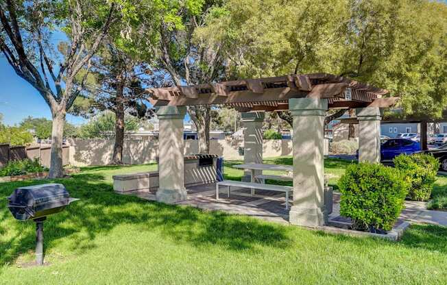 A park bench under a pergola in a sunny day.