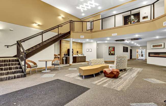 the lobby of a building with a staircase and couches