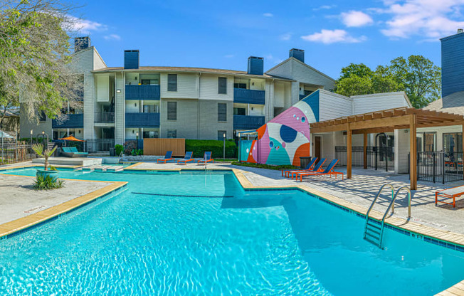 our apartments have a large swimming pool with chairs and umbrellas