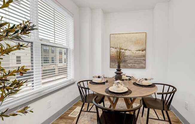 a dining room with a table and chairs and a large window at Meridian at CityPlace, Woodbury, MN 55125