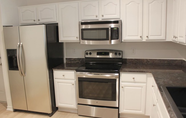 a kitchen with stainless steel appliances and white cabinets