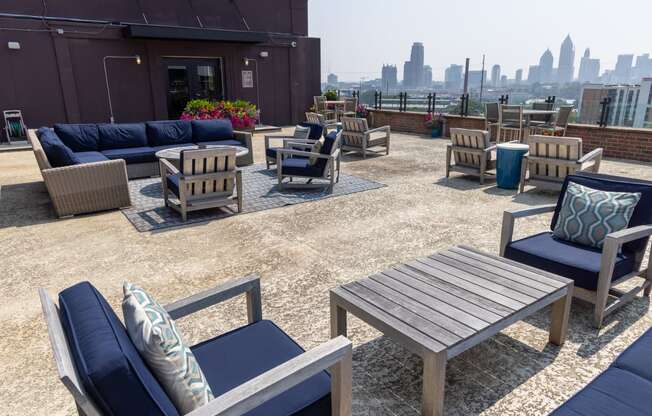 an outdoor patio with blue couches and chairs and a view of the city