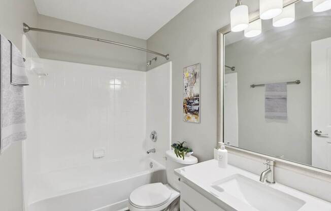 A white bathroom with a toilet, sink, and bathtub.