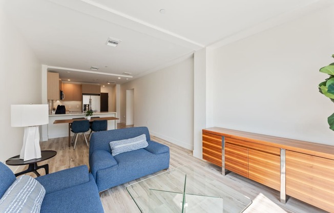 a living room with blue couches and a glass table