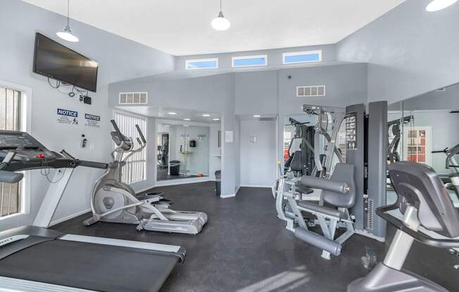 A gym with treadmills, weights, and exercise equipment at Urban WalkApartments on 6th Avenue, Arizona 85016