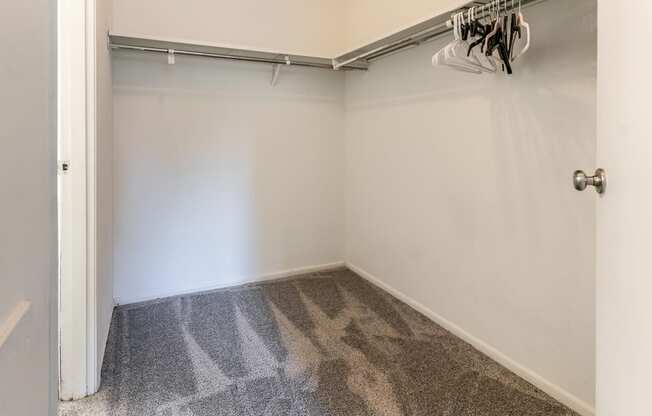 a room with a carpeted floor and a white wall with a garage door