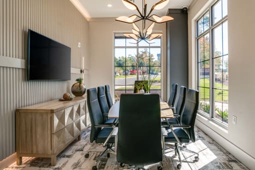 a conference room with a table and chairs and a tv