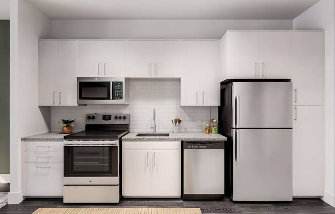 a kitchen with white cabinets and stainless steel appliances at Link Apartments® CYKEL Apartments, Charlotte , NC