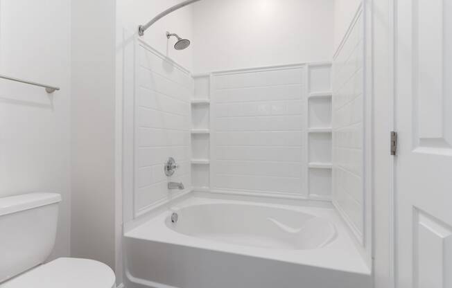 a white bathroom with a tub and a toilet