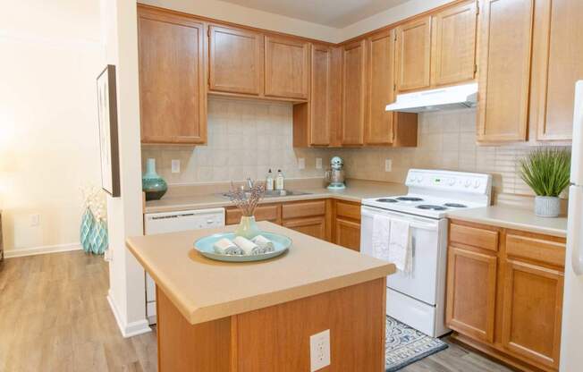 A kitchen with wooden cabinets and a white stove top oven.