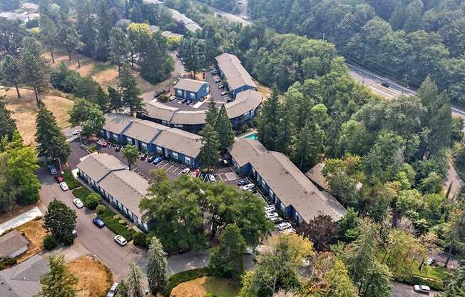 A large building surrounded by trees and a parking lot.