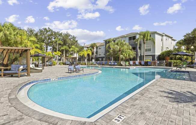 a large swimming pool with a hotel in the background