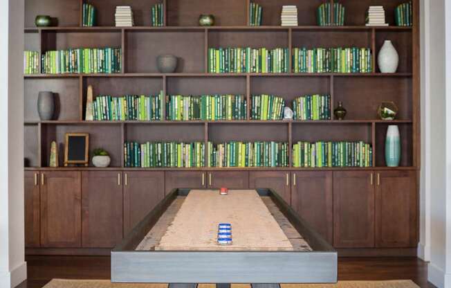 A shelf with books and vases on it.