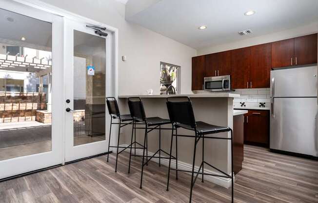 A kitchen with a bar stool and a fridge.