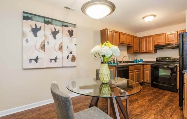 A kitchen with a table and chairs and a painting on the wall.