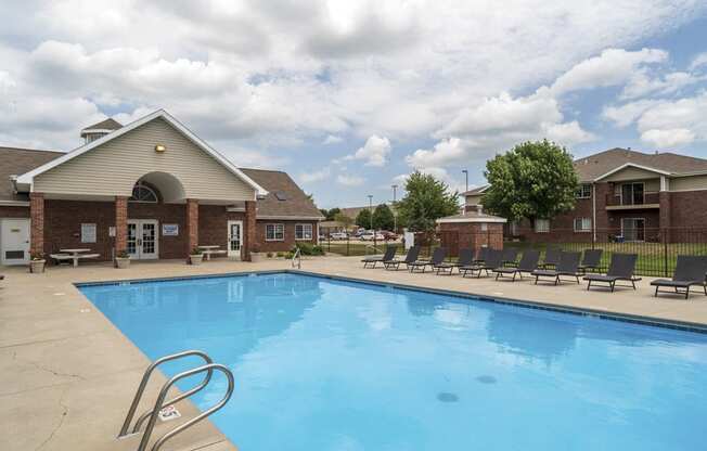 Large outdoor pool with lounge chairs at The Northbrook Apartments