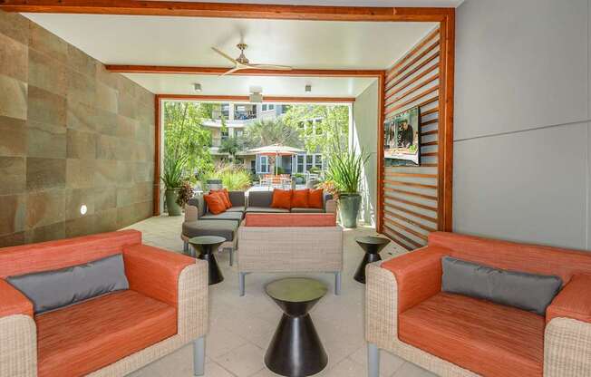 A patio with a table, two chairs and a sofa.