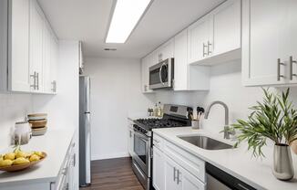 a kitchen with white cabinets and stainless steel appliances