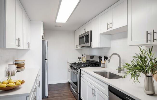 a kitchen with white cabinets and stainless steel appliances