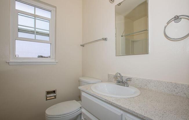 a white sink sitting under a mirror