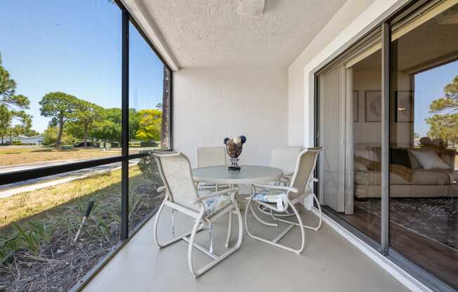 a patio with a table and chairs and a large window